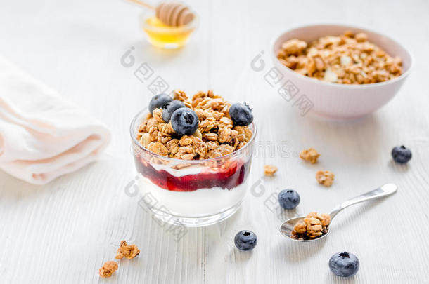 健身早餐与穆斯利，蜂蜜和浆果在白色桌子上