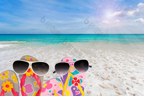 带太阳镜的<strong>沙滩鞋</strong>，热带海洋和天空背景。