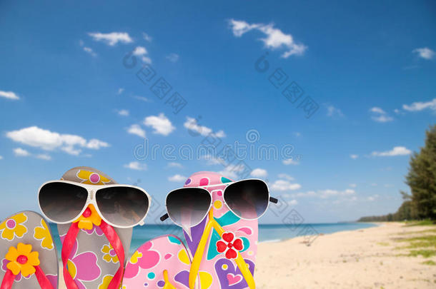 带太阳镜的<strong>沙滩鞋</strong>，热带海洋和天空背景。