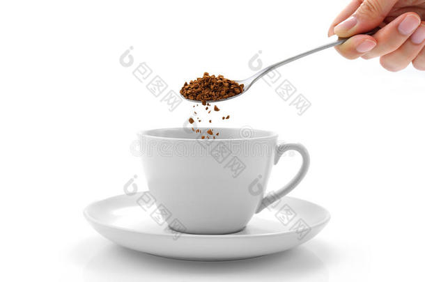 手从咖啡杯里的勺子里倒速溶咖啡