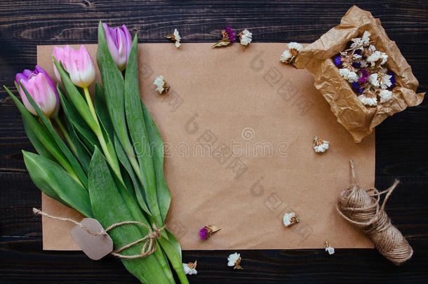 一束美丽的新鲜郁金香，装饰在木制的背景上。 花店工作场所