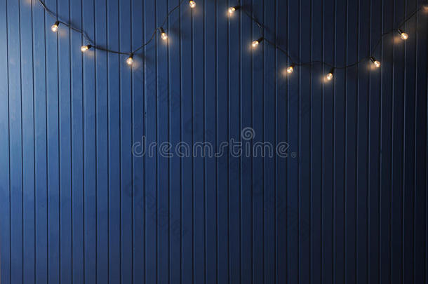 蓝色墙壁与<strong>复古花环</strong>的灯泡。 设计的纹理