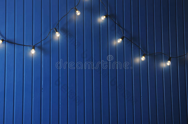 蓝色墙壁与<strong>复古花环</strong>的灯泡。 设计的纹理