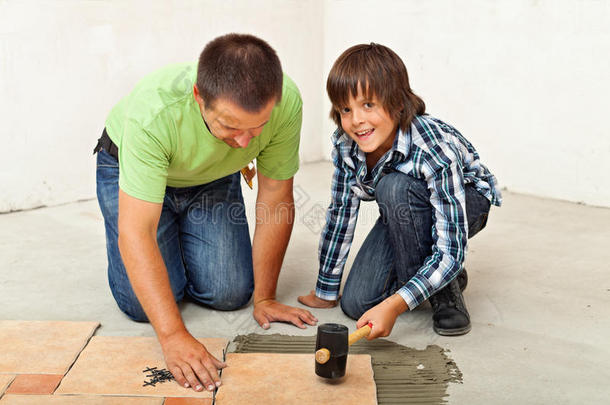 男孩帮助他父亲放置瓷砖