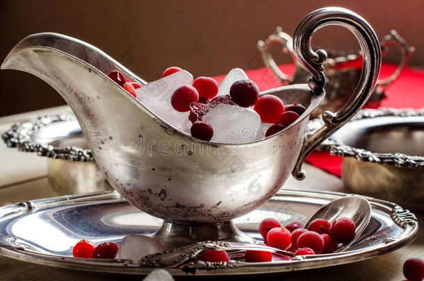 美丽的银碗和冰和红色浆果。 古董。