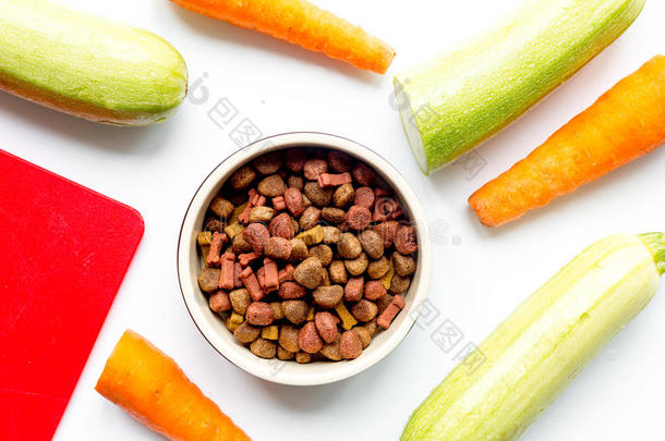 干狗粮与胡萝卜和西葫芦在桌子背景顶部视图