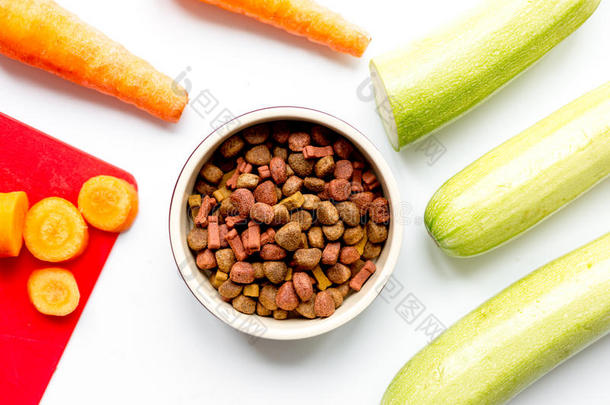 狗粮，胡萝卜和胡瓜在桌子背景顶部视图