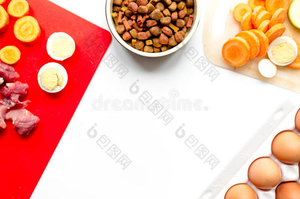 <strong>狗粮</strong>，鸡蛋，肉，胡萝卜和胡瓜在桌子背景顶部视图模型