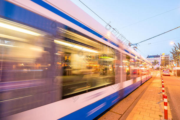 阿姆斯特丹。 电车在城市街道日落时超速行驶