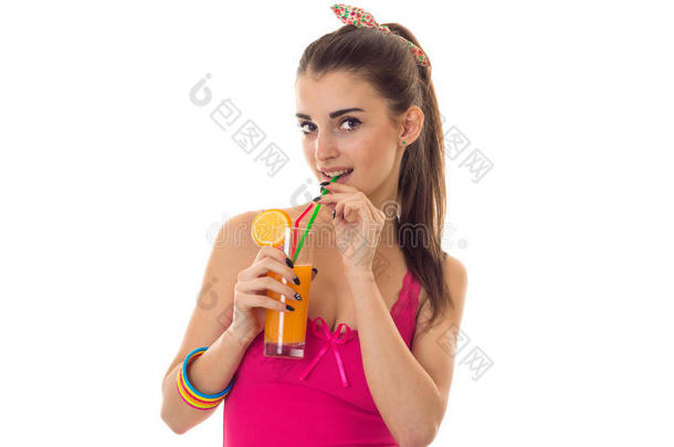 一个年轻的女孩穿着一件明亮的着一杯果汁<strong>喝了</strong>起来