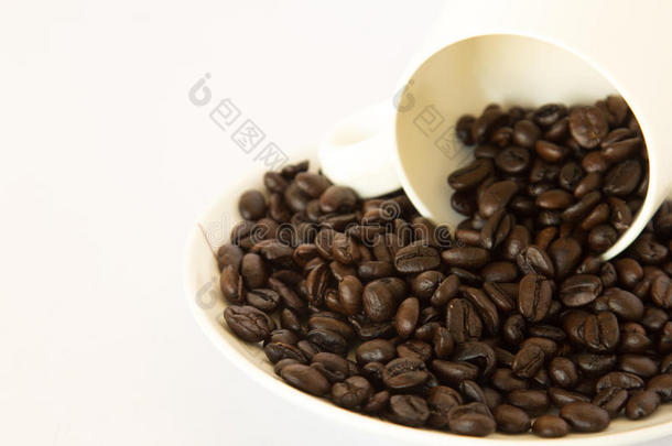 在白色背景上的白色咖啡杯中的咖啡豆。