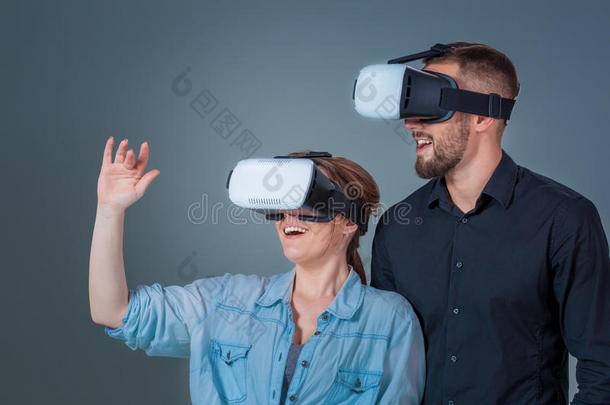 兴奋的年轻人和女人玩VR眼镜