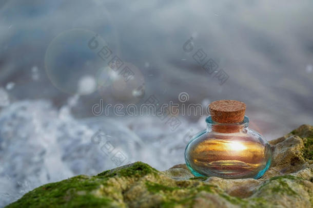 在海浪的岩石上发光的魔法瓶子里