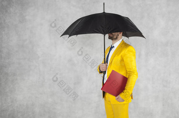 商人在雨伞下拿着公文包