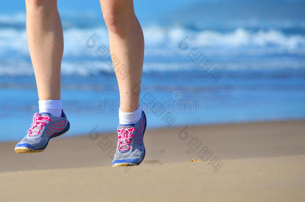 在海滩上健身和跑步，女人在海边沙滩上穿鞋跑步，健康的生活方式和运动