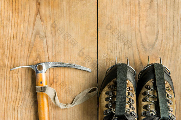 攀爬设备：<strong>登山鞋</strong>，冰具，冰斧，木制背景上的冰爪，顶部视图
