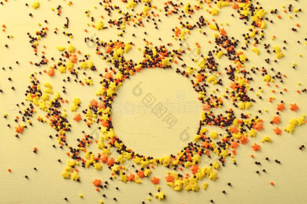 圆形框架由糖糖制成，黄色背景上的糕点装饰。