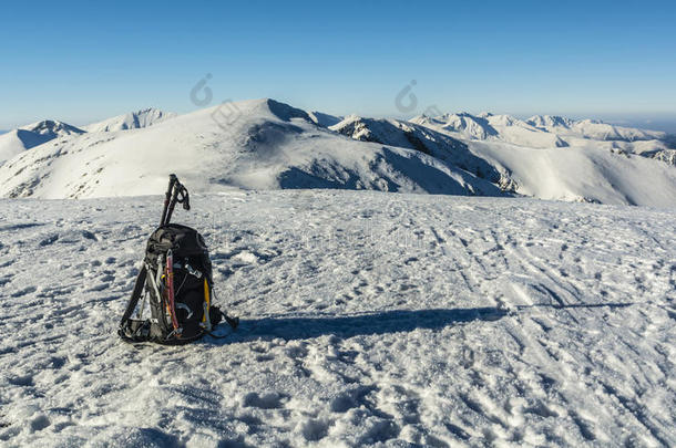 背包与冰斧和徒步旅行杆在冬天的山上