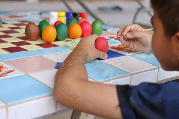 背面的小男孩着色鸡蛋与画笔准备复活节。