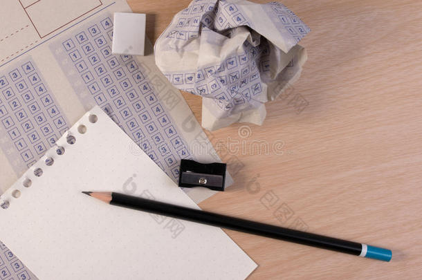 皱巴巴的纸球，老式的经典答题纸，铅笔，卷笔刀和纸张减少。