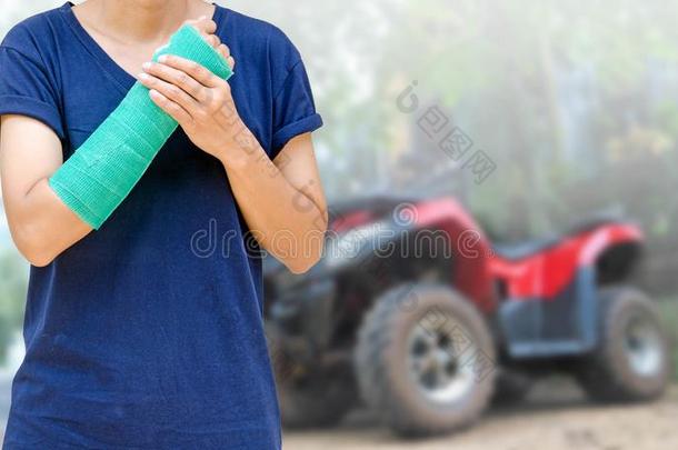 手臂断裂与绿色铸造模糊的<strong>红色汽车背景</strong>，意外保险的概念