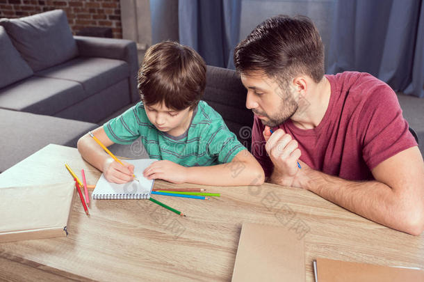 父亲帮助集中儿子做作业