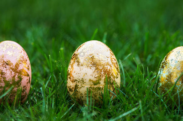 绿色草地背景上的金色复活节彩蛋
