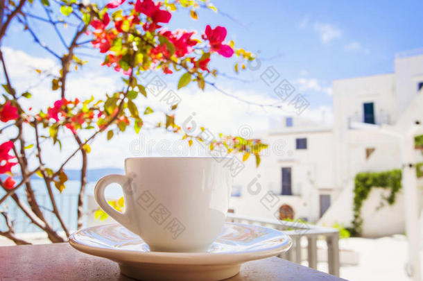 一杯咖啡在桌子上，背景是意大利小镇