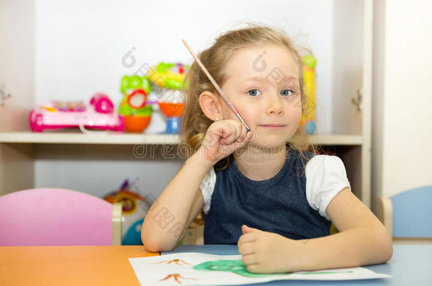 可爱的小女孩在托儿所里画画笔和油漆。 蒙台梭利学前班幼儿园的孩子。