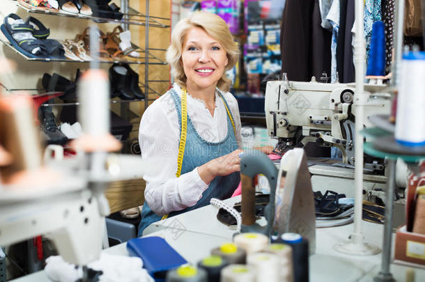 有吸引力的中年妇女裁缝使用缝纫机