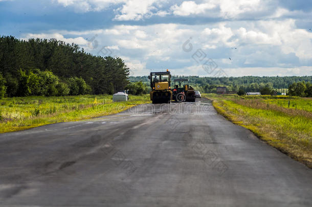 大队道路工人在夏季借助特种设备沥青在道路上铺设沥青