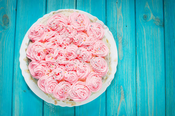 蓝色木材背景上的粉红色奶油蛋糕。 粉红色蛋糕。