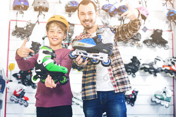 父子展示他们在体育商店买的溜冰鞋