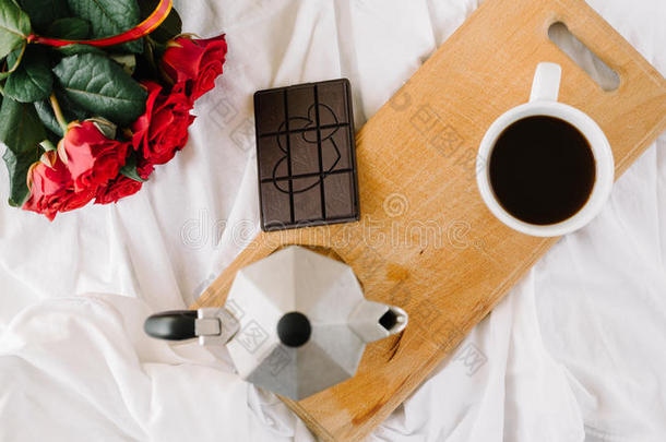 一杯咖啡，木板上的咖啡，白色背景上的一束<strong>红玫瑰</strong>