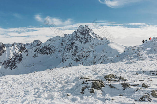华丽的冬季山脉景观与一群徒步旅行者攀登在顶部