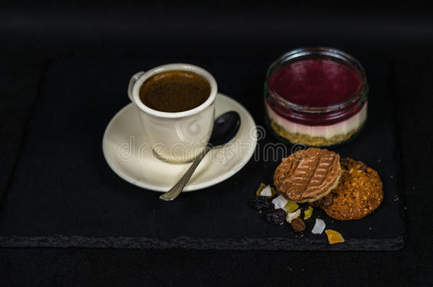 芳香的黑咖啡在<strong>一杯奶</strong>油，甜草莓甜点和两个棕色黄油饼干