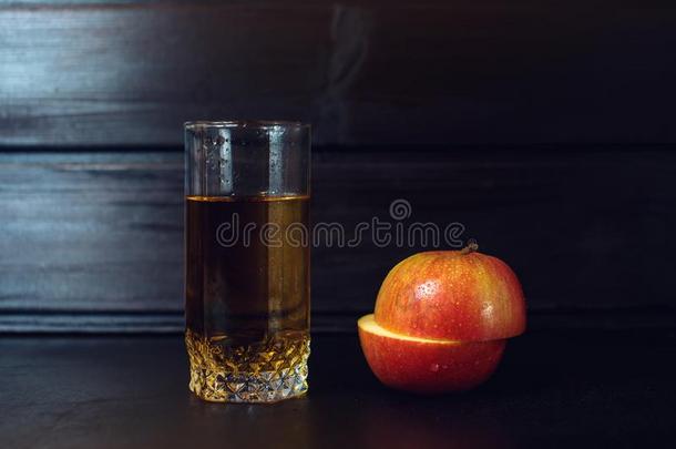 一杯苹果汁和切片苹果在深色的木头上