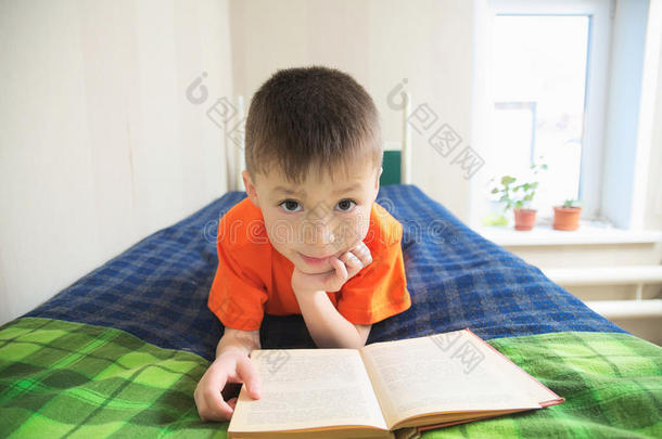 儿童教育，男孩<strong>看书</strong>躺在床上，孩子<strong>肖像</strong>微笑与书，教育有趣的故事书