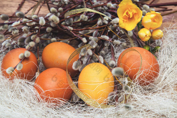 橙色和黄色的复活节彩蛋，有柳树的枝条，春天