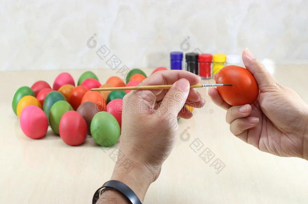 年<strong>轻放</strong>松的人的手在大理石顶部画彩色的鸡蛋，用copy空间背景准备复活节。