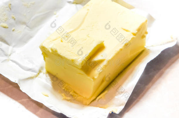 奶油黄油在它未包装的铝箔纸上。 在光桌上隔离