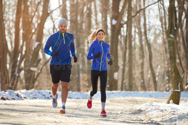 冬天的夫妇在大自然中一起跑步