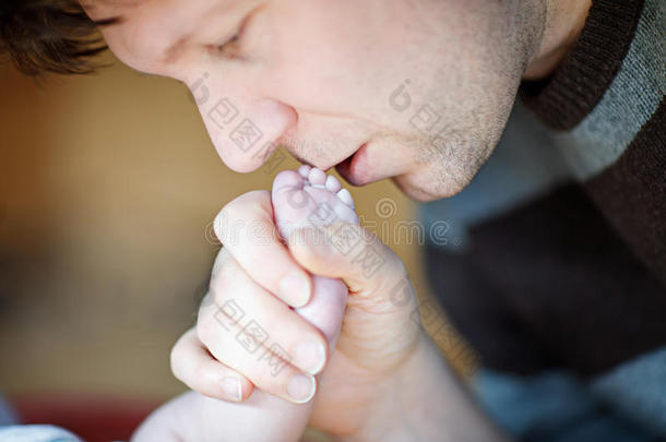父亲亲吻新生婴儿的脚。