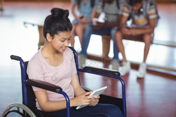 残疾女学生使用数字平板电脑与同学在背景