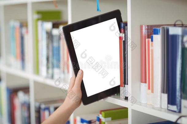 学生在图书馆书架上保存数字平板电脑的手
