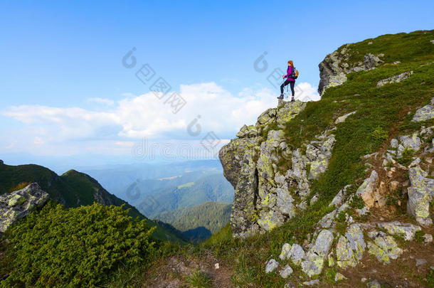 女孩在悬崖边缘的高山上。