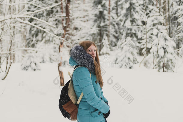 穿着蓝色外套<strong>的</strong>女孩在<strong>寒冷的冬天的</strong>森林里扔雪。 女人<strong>的冬天</strong>心情愉快