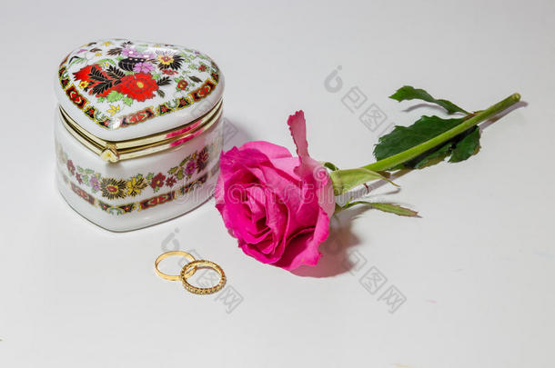 艺术珠宝箱与明亮的粉红色玫瑰和黄金订婚戒指在轻的背景。