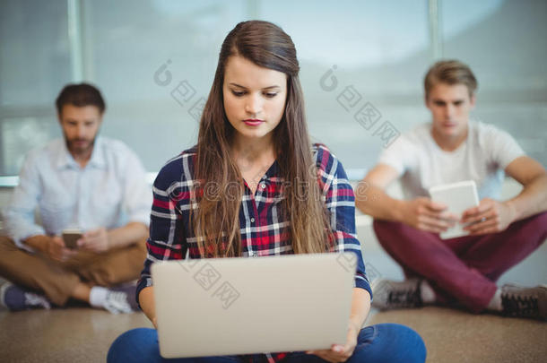 企业高管坐在地板上使用笔记本电脑