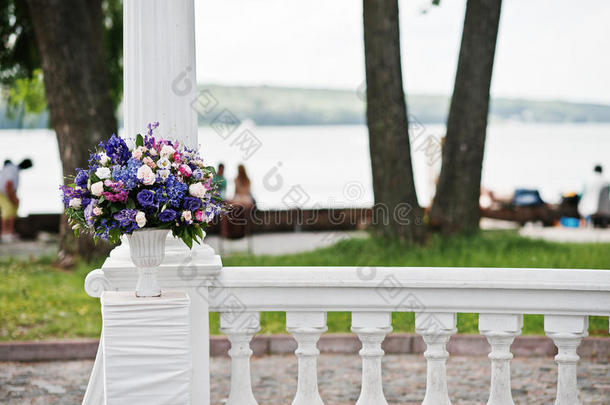 用紫罗兰和紫色的花装饰婚礼拱门。